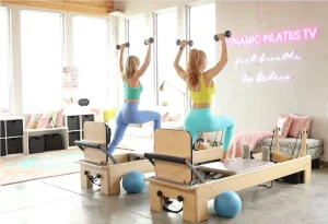 Tiffany Burke and Korin Nolan in the Dynamic Pilates TV studio on wooden reformers with Dumbbell weights
